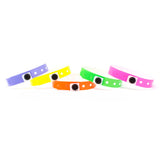 Five colorful silicone wristbands with white polka dots and a black oval ID window, arranged in a fan shape on a white background.